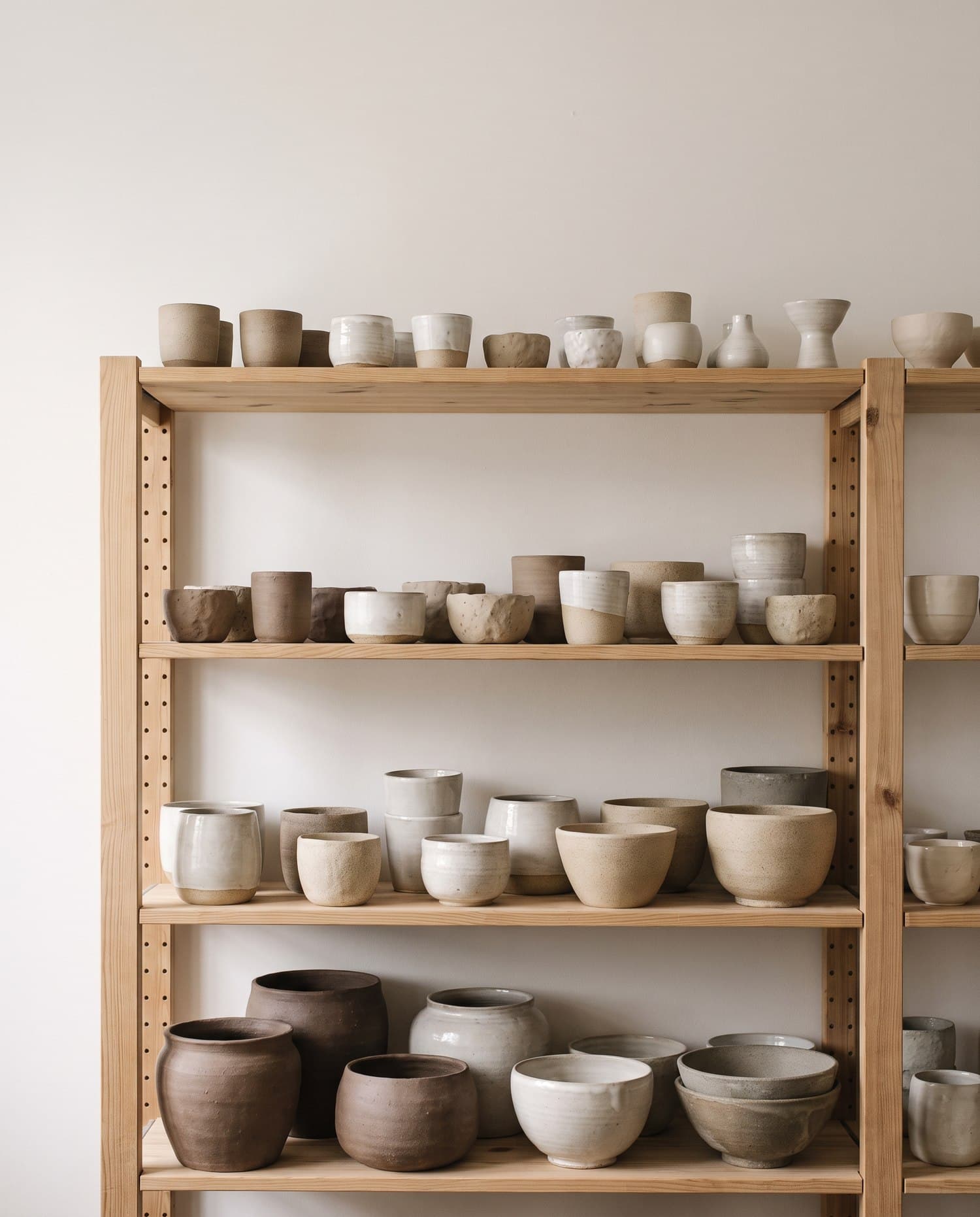 A shelf holding a developing collection of related ceramic vessels